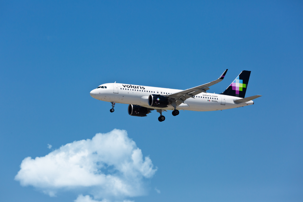 Volaris airbus flying across the blue sky.