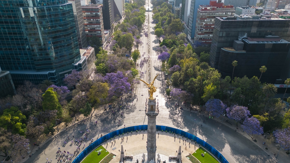 Aerial view of Paseo de la Reforma at daylight, with its boulevard and iconic statue.