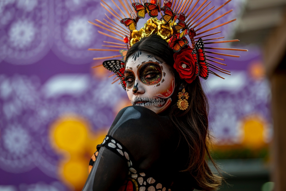 A woman wearing traditional Catrina face painting and costume