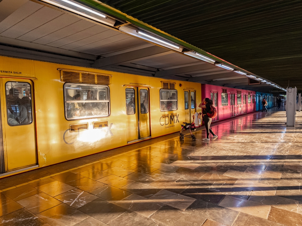 Ciudadanos esperando transporte en estación de metro de CDMX.