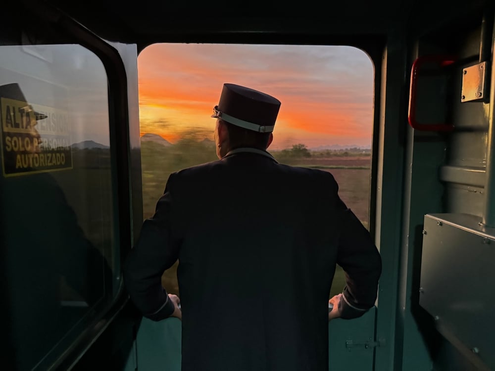 Oficial mirando el atardecer por la ventana del Tren Chepe, Los Mochis.