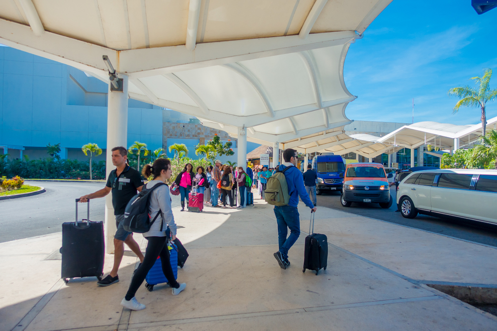 Gente caminando con sus valijas en el aeropuerto de Cancún