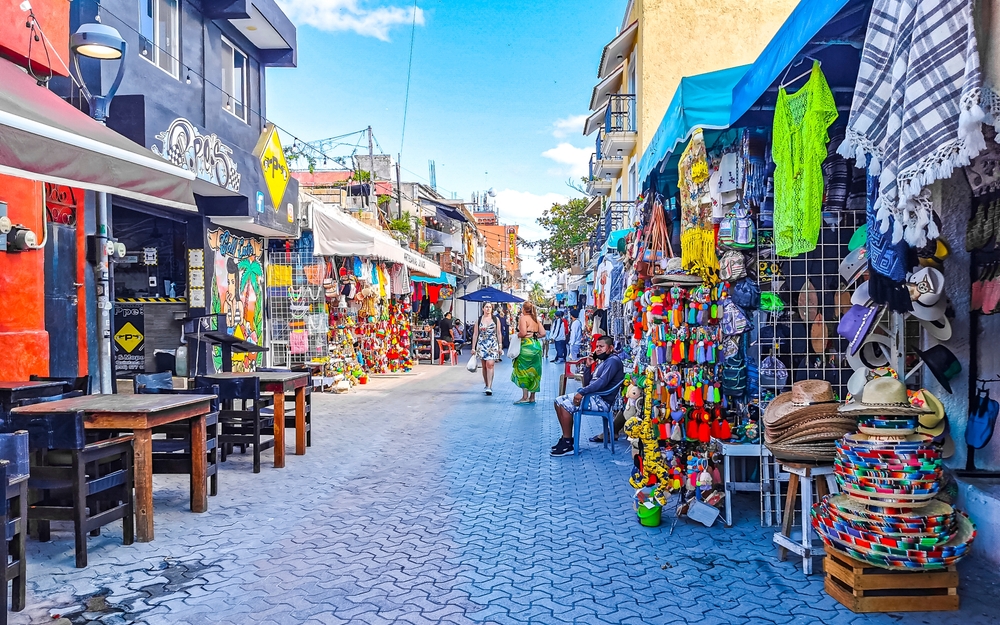 Calles turísticas típicas y coloridas y aceras entre restaurantes, tiendas y hoteles en Isla Mujeres en Cancún, México.