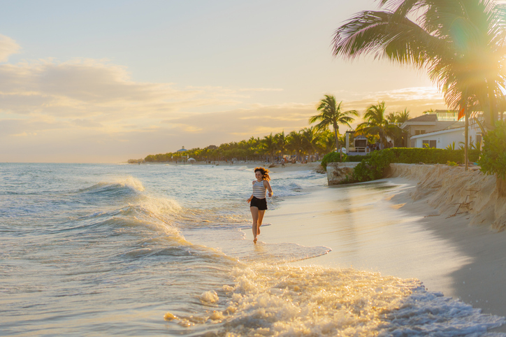 Mujer corriendo por las costas de Cancún al atardecer.
