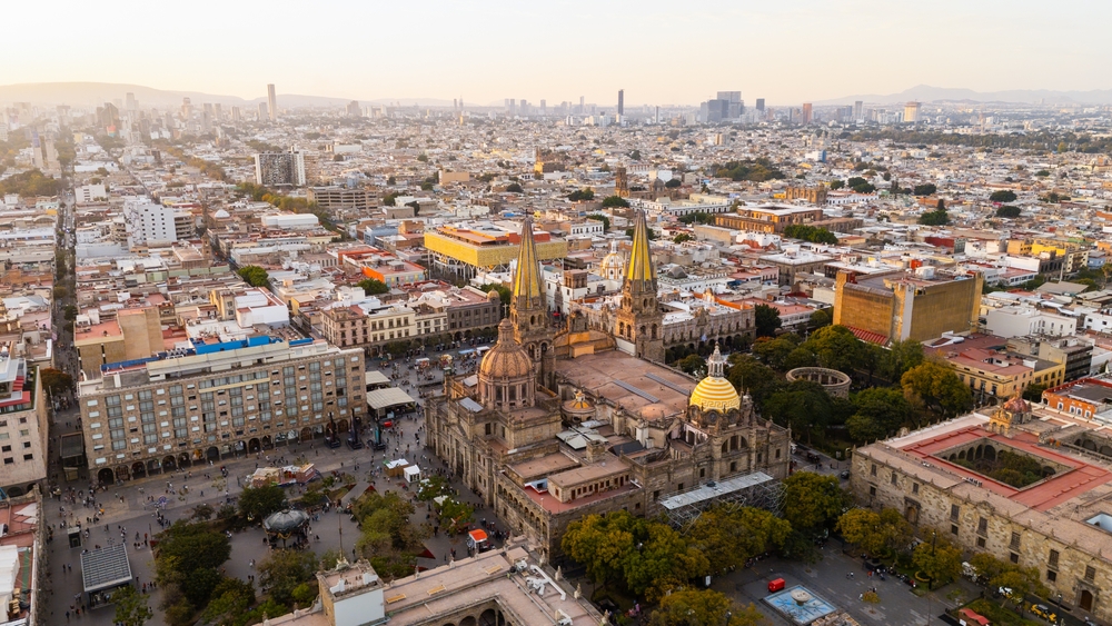 Aerial view of Guadalajara Cathedral and the surrounding downtown area bathed in the warm glow of sunset
