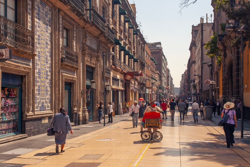 Locales y turistas, tiendas y restaurantes en la avenida Madero, una calle peatonal en el centro histórico de CDMX.