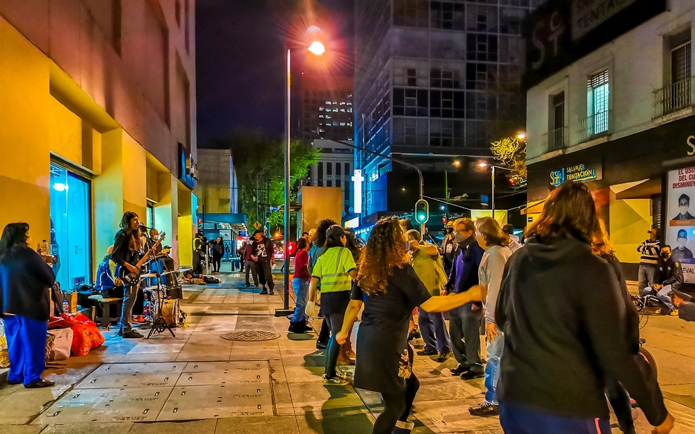 Street with nightlife, musicians, shops, and people in the Historic Center of Mexico City, Mexico.