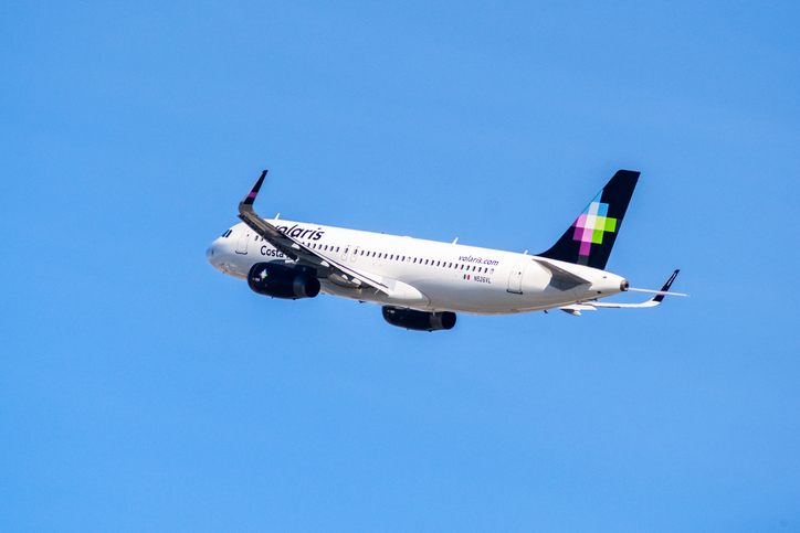 Volaris airbus flying across the blue sky.