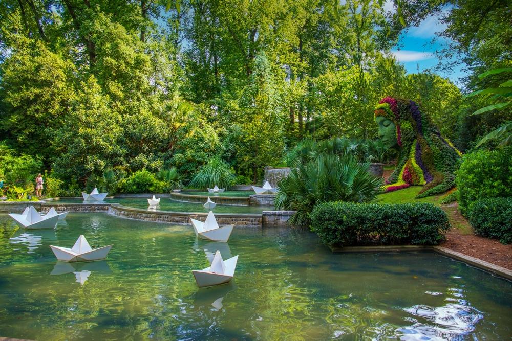 Grullas en una laguna junto a la escultura de flores La Diosa de la Tierra en el Jardín Botánico de Atlanta,