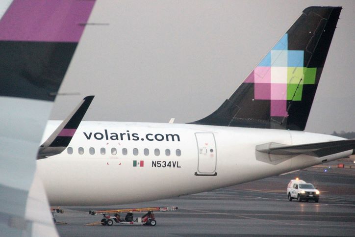 The back rear of a Volaris airbus parked in the airport.