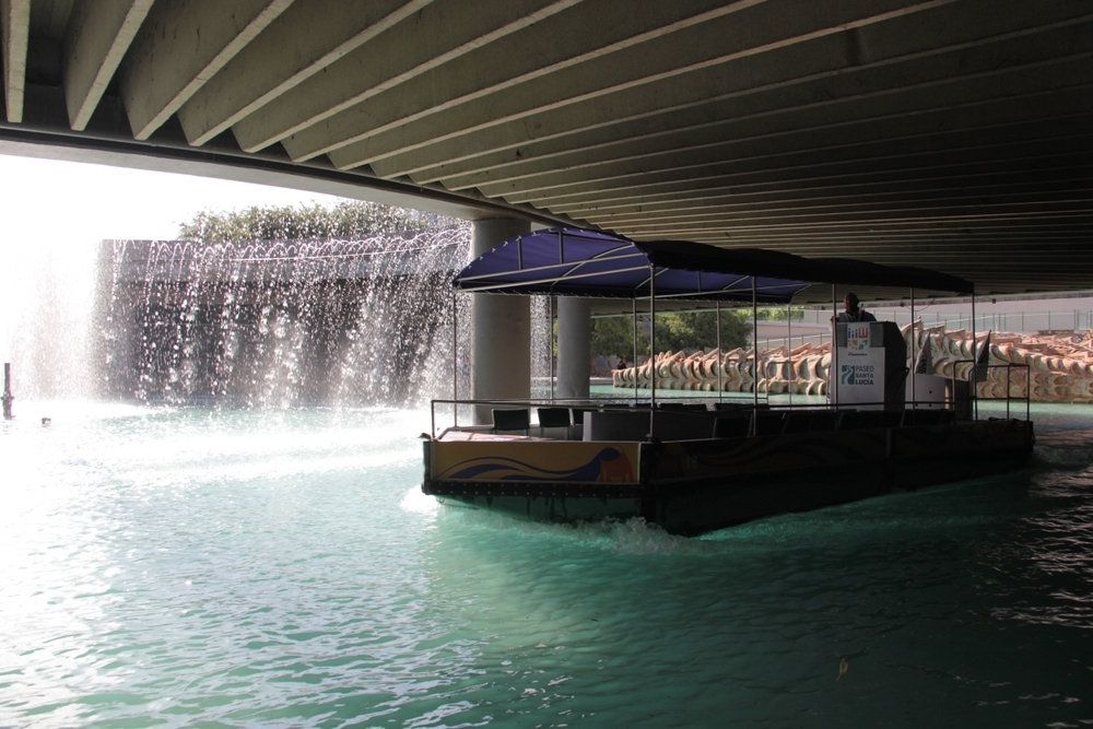 Tourist boat riding below a bridge in Santa Lucia Riverwalk from the Macroplaza to Fundidora Park