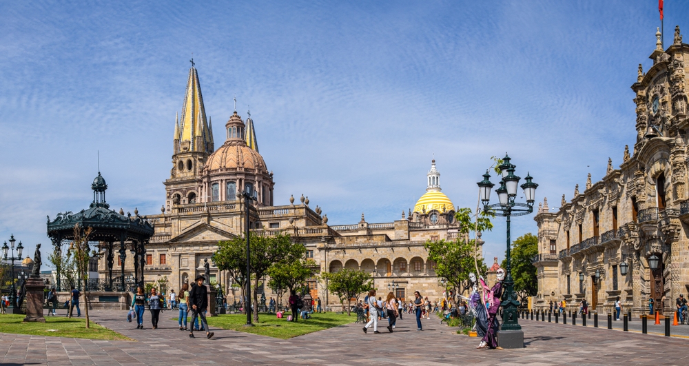 Tourist and locals enjoying the day during a day of the dead celebration, at the Plaza de Armas, with the Guadalajara Cathedral, and the Parroquia
