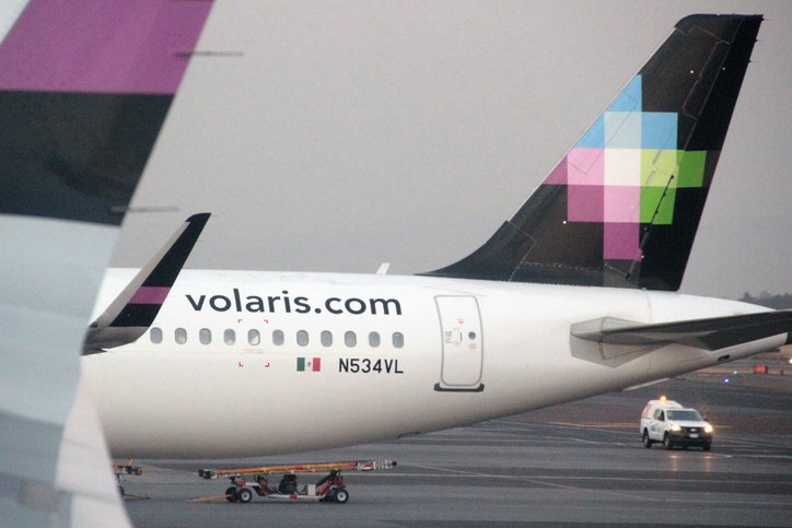 Ala trasera de un avión de Volaris estacionado en el aeropuerto.
