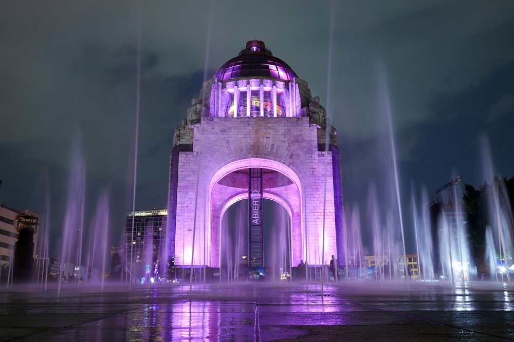 Monumento a la Revolución en la Plaza de la República, con aguas danzantes y luces de neon en la noche.