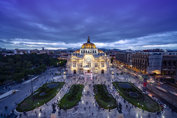 Palacio de Bellas Artes iluminado al anochecer, visto desde las alturas.