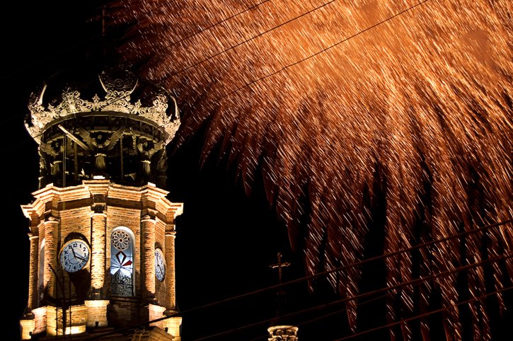 Fuegos artificiales sobre la cúpula de la Iglesia Nuestra Señora de Guadalupe, por la noche.