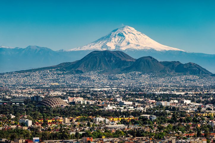 Vista panorámica de la Ciudad de México con el volcán Popocatépetl al fondo.