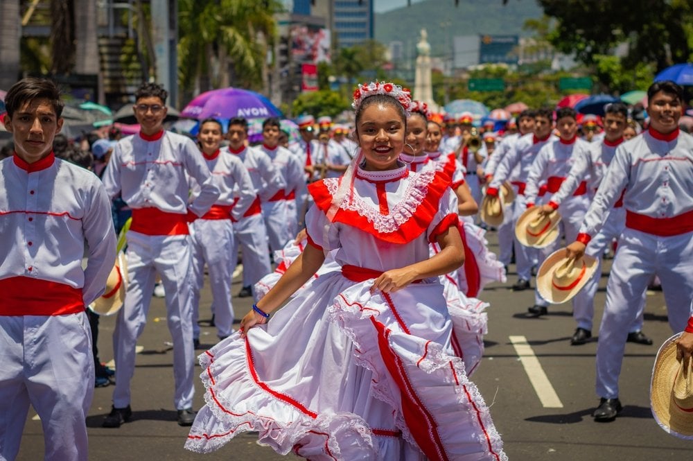 People in traditional costumes perform dances during the El Comercio parade, as part of the festivities in San Salvador.
