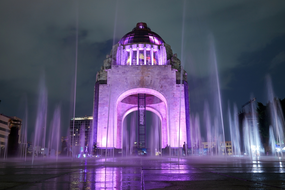 Monumento a la Revolución, en Plaza de la República, iluminado durante el anochecer y rodeado de aguas danzantes.