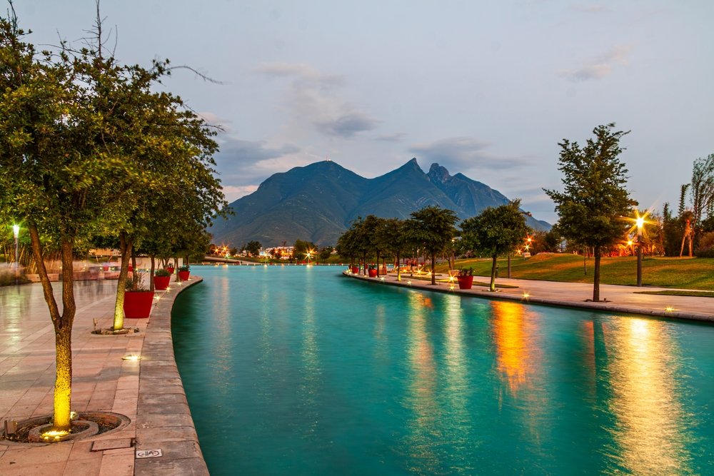 Paseo Santa Lucía iluminado al atardecer, con el Cerro de la Silla de fondo.