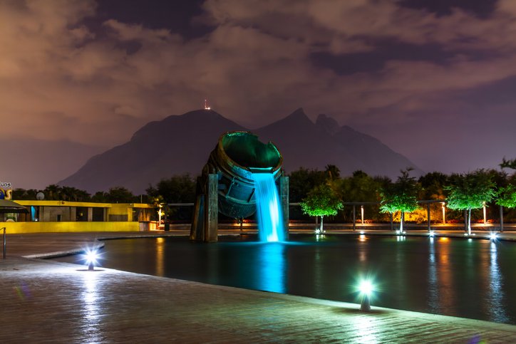 Iconic fountain at Monterrey’s Fundidora Park at night, with the famous Cerro de la Silla hills in the background.