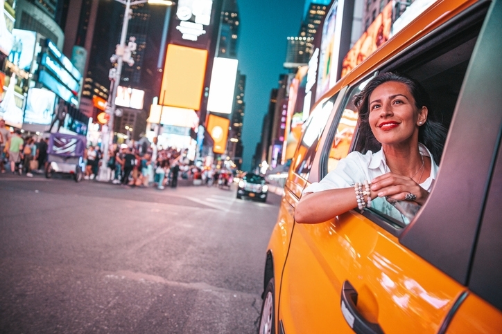 Mujer joven paseando en taxi por Times Square.