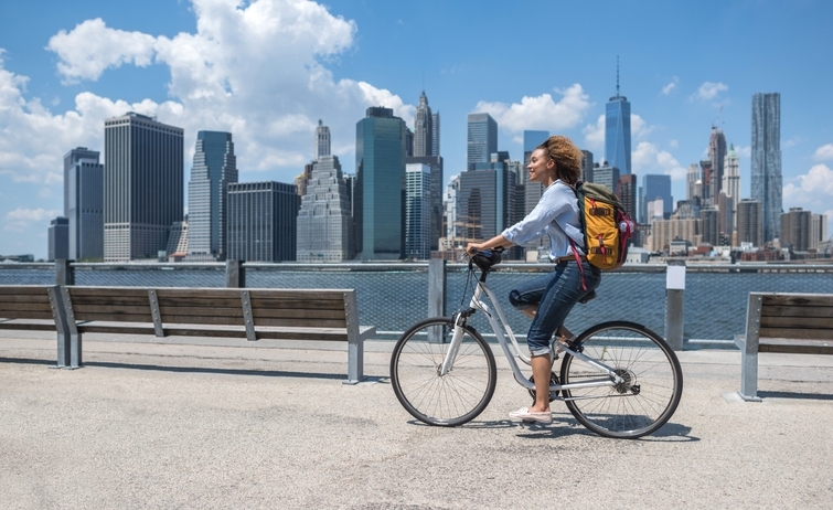 Mujer joven montando en bicicleta por las calles de Nueva York.