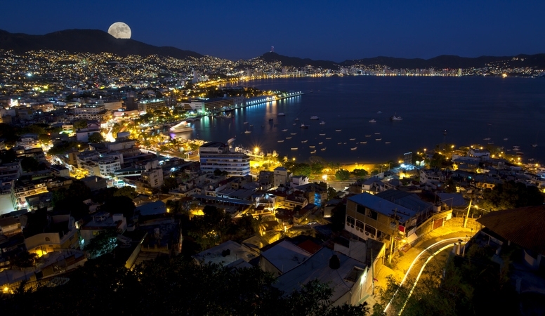 Vista aérea de la ciudad de Acapulco iluminada por la noche.