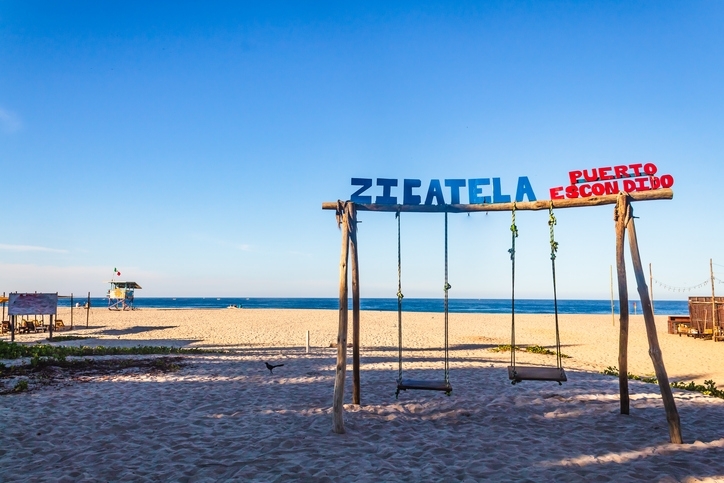 Columpios en la playa con letrero de Zicatela.