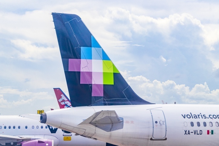The back wing of a Volaris airbus parked in the airport.