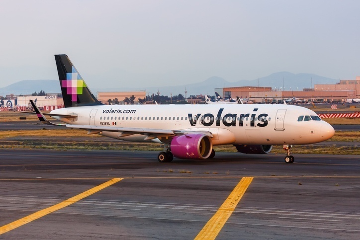 Volaris airbus during landing process at sunset.