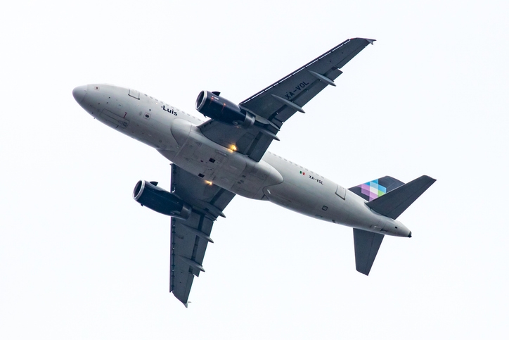 Volaris airbus “Luis” in a cloudy sky, seen from below.