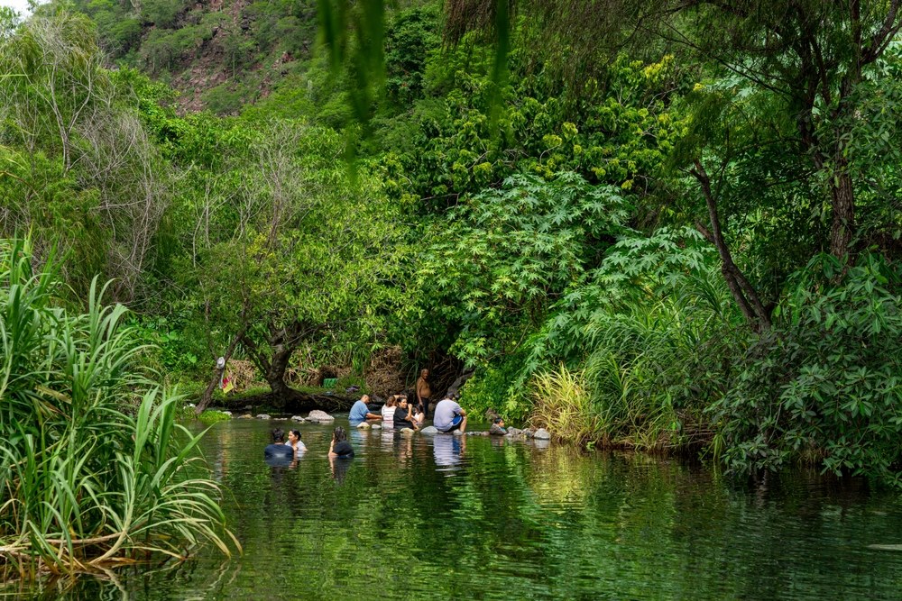 Un grupo de personas se baña en uno de los balnearios de aguas manantiales de Colima.