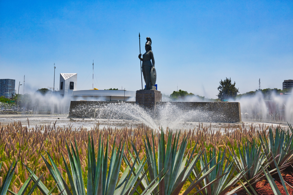 Monumento Minerva detrás de plantaciones de tequila, emblema de Guadalajara.