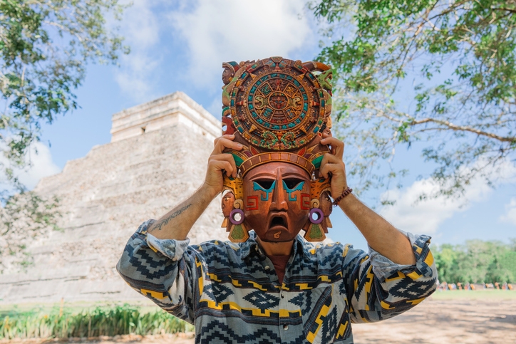 A man holding a Mayan mask at Chichen Itzá.