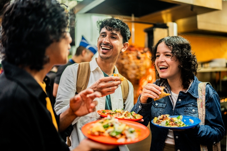 A group of tourists enjoying tacos al pastor