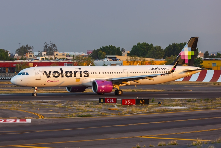 Volaris plane in landing platform at sunset.