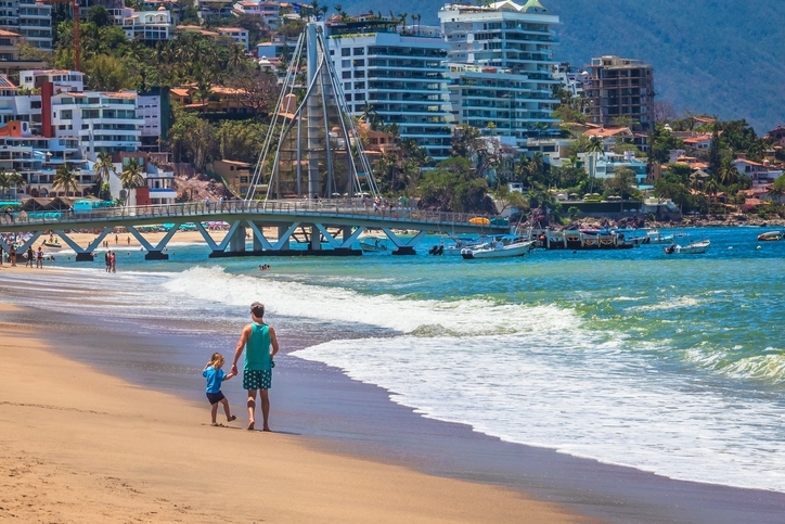 Father and daughter strolling through the beach of Puerto Vallarta.