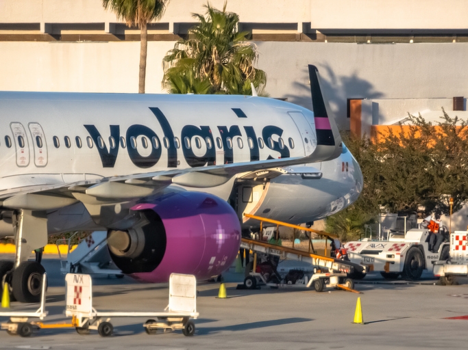 Close-up of a Volaris airbus parked in the boarding platform.