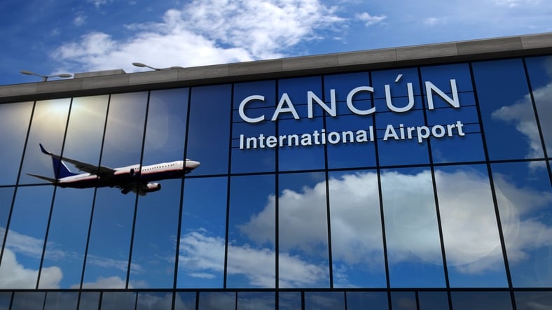 Reflejo de un avión en la fachada de cristal del Aeropuerto Internacional de Cancún.