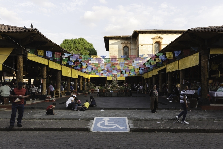 Mercado tradicional decorado con papel picado, con personas comprando comida típica en Uruapan.