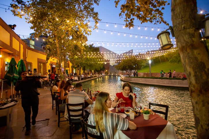Zona gastronómica de Monterrey. Personas cenando junto a un canal.