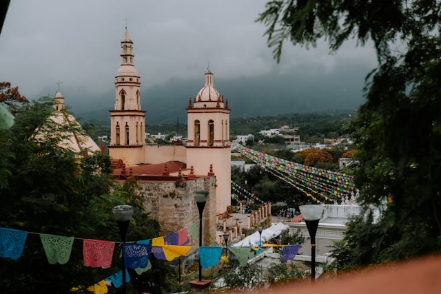 Vista de las cúpulas de una iglesia en Monterrey. Guirnaldas de colores adornan el lugar.