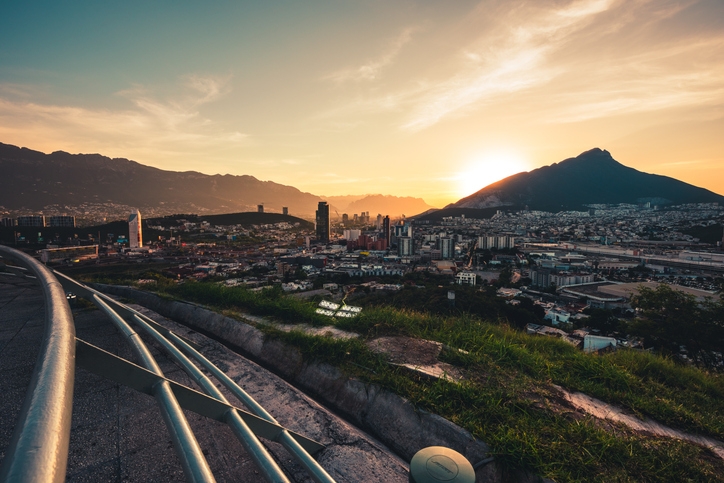 Vista de Monterrey al atardecer. Edificios y montañas.