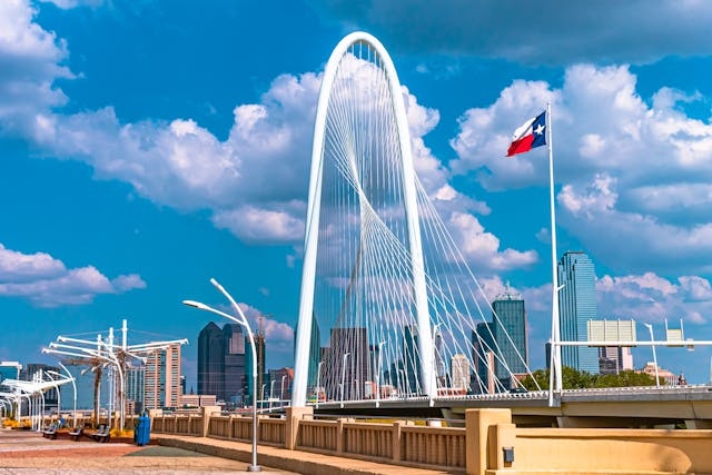 Puente Margaret Hunt Hil de día. Bandera de Texas flameando.