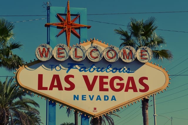 Letrero clásico de Las Vegas con el mensaje "Welcome to Fabulous Las Vegas, Nevada", rodeado de palmeras.
